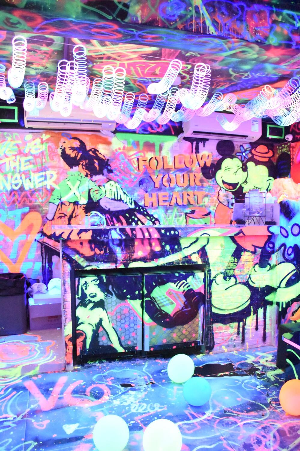 Neon graffiti walls inside the Sketch Studios blacklight room